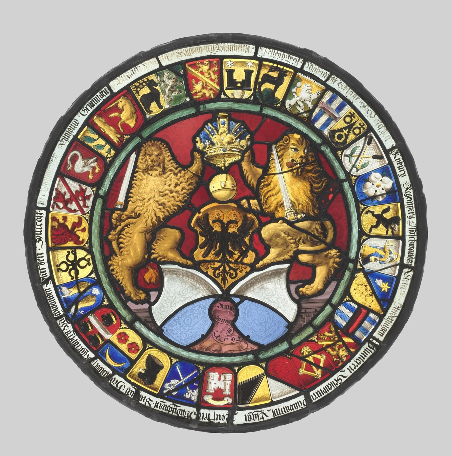 A central eagle shield, a crown, and paired lions occupy the largest area. Smaller shields form a ring around them, enclosed by lettering and a coloured border.