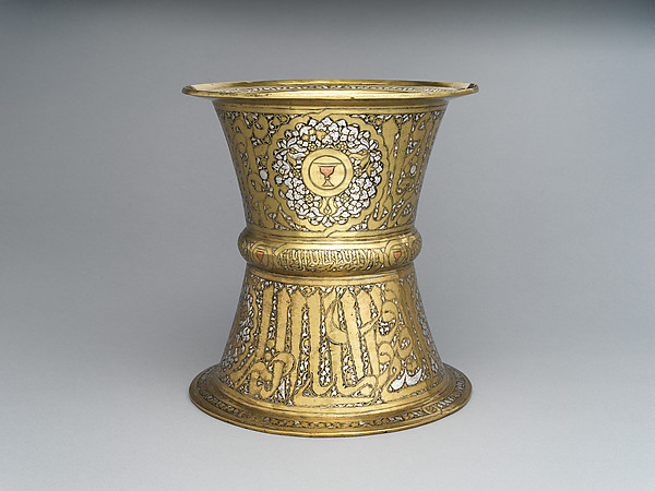 An inlaid brass stand with a cup emblem inside a roundel on the upper section and large inscription bands around the body.